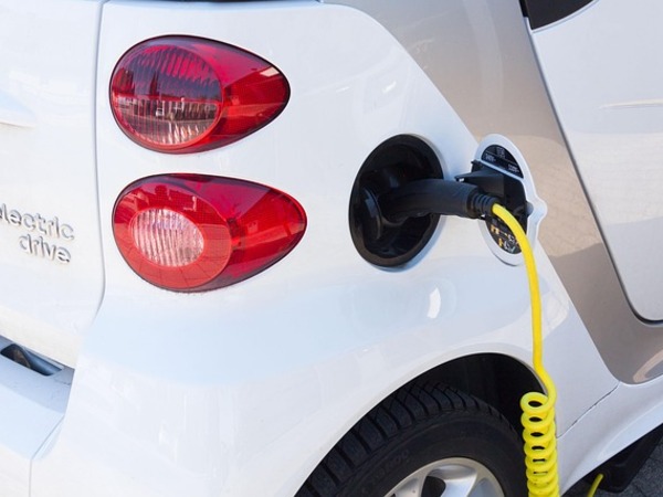 Afbeelding van een auto die elektrisch opgeladen wordt.